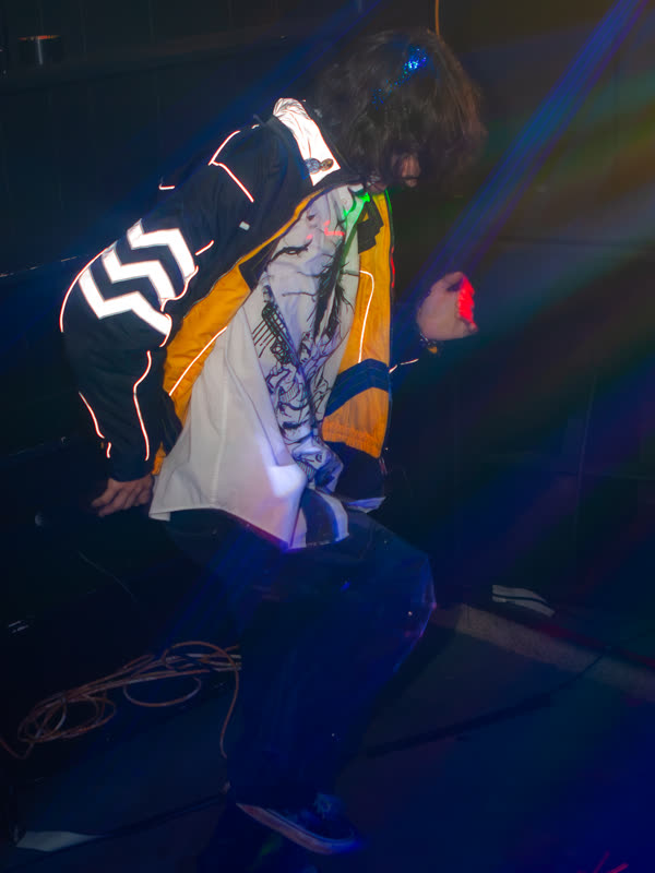 Guest raising a jacket above the dance floor at Dress to Impress, photographed by Jay Snaps