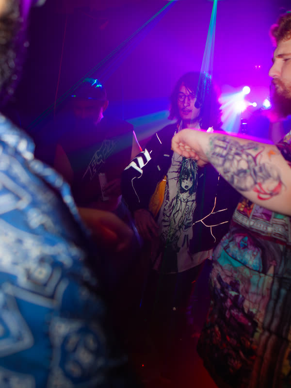 Partygoers dancing under purple lights at Dress to Impress, photographed by Jay Snaps