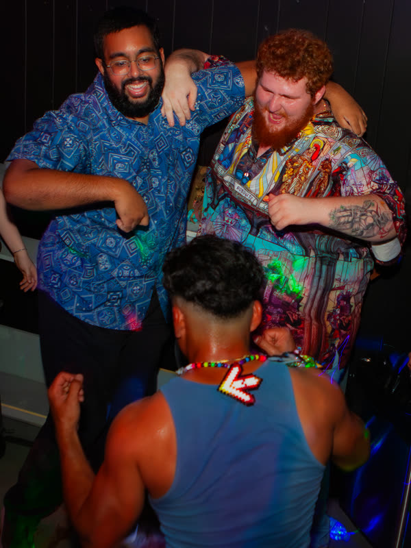 Friends smiling together on the dance floor at Dress to Impress, photographed by Jay Snaps