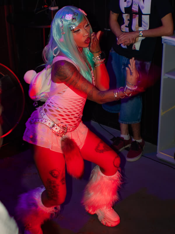 Guest dancing in a pink top and turquoise wig at Dress to Impress, photographed by Jay Snaps