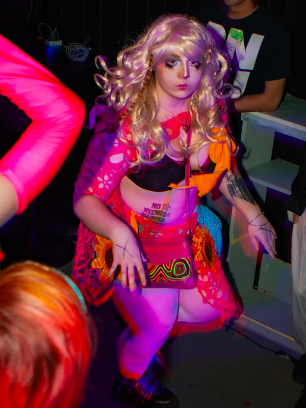 Guest dancing in a pink outfit and lavender wig at Dress to Impress, photographed by Jay Snaps