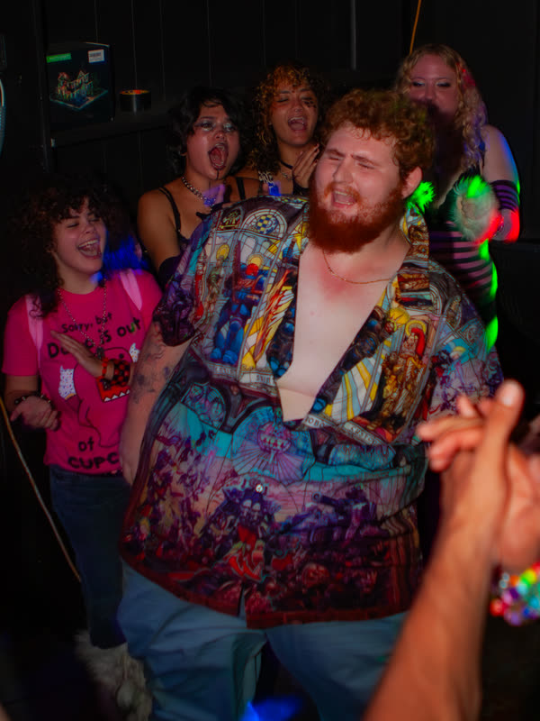 Guest smiling in a patterned shirt at Dress to Impress, photographed by Jay Snaps