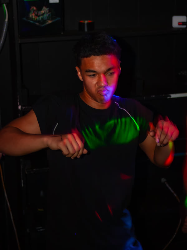 Guest in a black outfit and bright green gloves at Dress to Impress, photographed by Jay Snaps