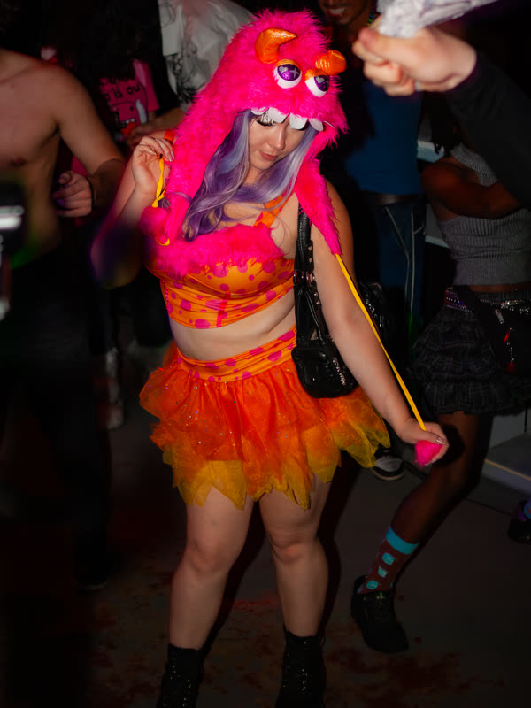 Guest dancing in a pink character hat at Dress to Impress, photographed by Jay Snaps